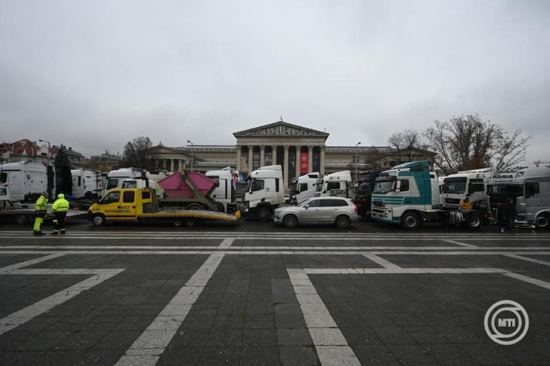 A fuvardíjak emelése ellen tüntető kamionosok gépjárművei sorakoznak a fővárosi Hősök terén 2025. december 22-én. Az Építési és Közlekedési Minisztérium december 19-én hét fuvarozói szervezet képviselőivel írt alá megállapodást; minden fuvarozói szervezettel megegyezett, egy szervezet kivételével. A minisztérium tájékoztatása szerint a megállapodás aláírásával a fuvardíjak méltányos emelése valósul meg 2026-ban. MTI/Balogh Zoltán