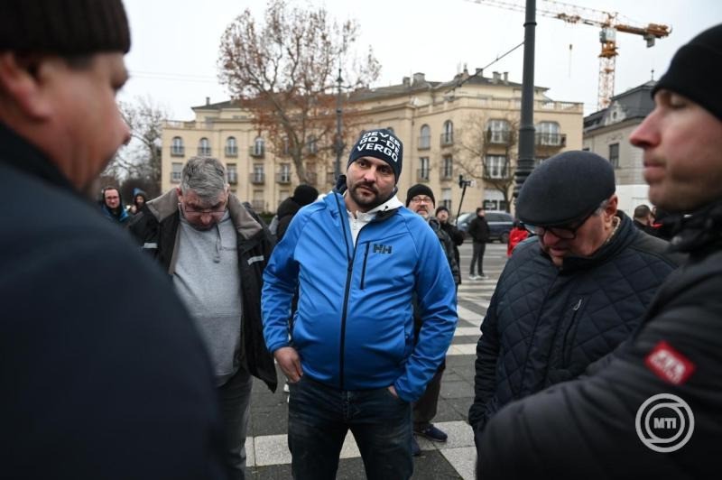 A fuvardíjak emelése ellen tüntető kamionosok, középen Orosz Tibor, a rendezvény szervezője a fővárosi Hősök terén 2025. december 22-én. Az Építési és Közlekedési Minisztérium december 19-én hét fuvarozói szervezet képviselőivel írt alá megállapodást; minden fuvarozói szervezettel megegyezett, egy szervezet kivételével. A minisztérium tájékoztatása szerint a megállapodás aláírásával a fuvardíjak méltányos emelése valósul meg 2026-ban. MTI/Balogh Zoltán