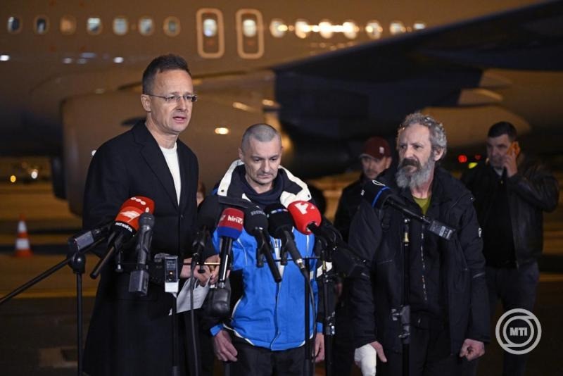 Szijjártó Péter külgazdasági és külügyminiszter (b) nyilatkozik, mellette a vele Budapestre érkező két kényszersorozott kárpátaljai magyar hadifogoly (b2 és b3) a Liszt Ferenc Nemzetközi Repülőtéren 2026. március 5-én hajnalban. A kényszersorozott, magyar állampolgársággal is rendelkező, magyar nemzetiségű férfiak elengedését a miniszterrel előző nap Moszkvában folytatott tárgyalásán hagyta jóvá Vlagyimir Putyin orosz elnök. MTI/Bodnár Boglárka